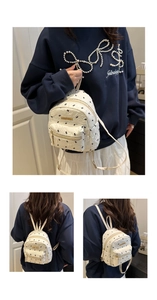 Detail of white mini backpack with bird embroidery and gold Fashion metal logo