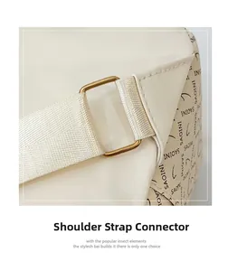 Détail du sac en cuir beige montrant la boucle métallique et l'attache de bandoulière