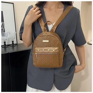 Détail d'un petit sac à dos marron monogramme avec rivets dorés et poche zippée