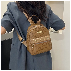 Détail du sac à dos marron à monogramme avec clous dorés et plaque de la marque