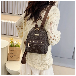 Sac à dos vintage marron avec rivets dorés et larges bretelles porté par un mannequin