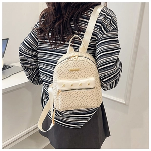 Détail du mini sac à dos crème avec imprimé SADINE et rivets dorés porté à l'arrière