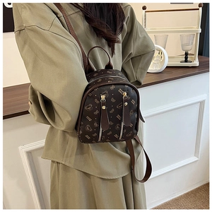 Détail d'un sac à dos marron avec imprimé ours porté par un mannequin dans un magasin