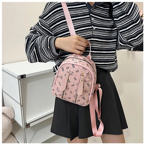 Close-up of pink mini backpack featuring cartoon bear prints and vertical zipper pockets