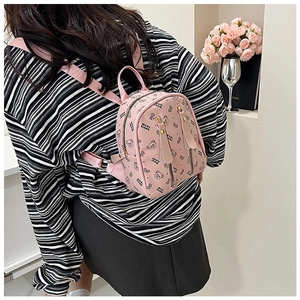 Vue détaillée de l'arrière d'un mini sac à dos rose avec motif ours et texture cuir