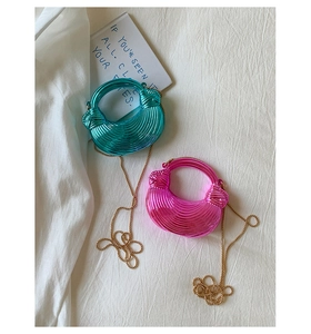 Close-up of mini metallic box bags in peacock blue and rose pink with acrylic chain