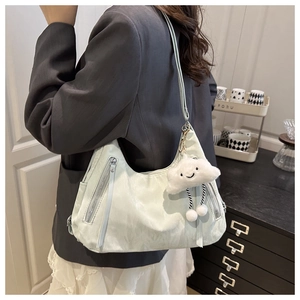 Detail of light mint green hobo bag with parallel zippers and plush cloud pendant charm