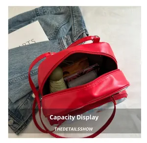 Detailed internal view showing large capacity and zipper compartments of the red shoulder bag