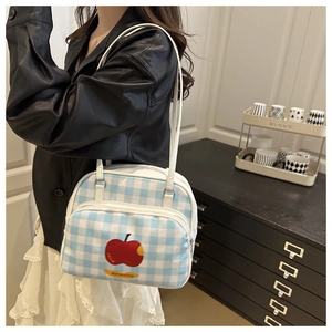 Close-up of blue gingham shoulder bag featuring red apple print and double zipper design