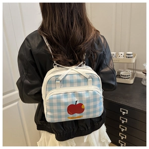 Close-up of blue plaid backpack with apple print and white adjustable shoulder straps