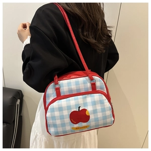 Detail of blue and white checkered handbag with red straps and apple pattern