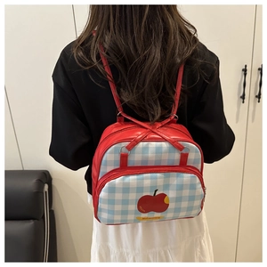 Rear view of a mini checkered backpack with red apple design and adjustable leather straps
