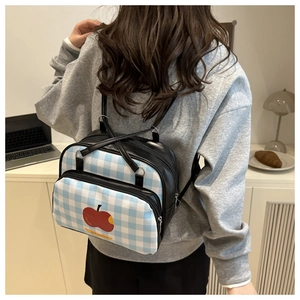 Detail of Korean style backpack with blue-white checkers and red apple print on leather