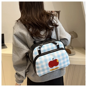 Blue plaid mini backpack with red apple print worn by a model on the back