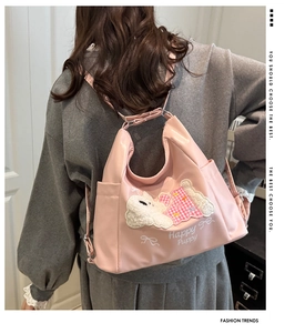 Rear view of a pink cartoon puppy tote bag worn by a model in a casual setting