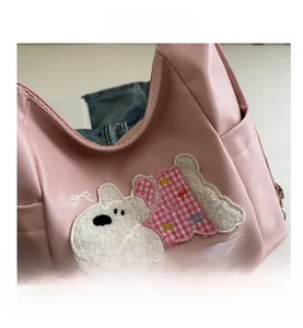 Close-up of pink PU leather tote bag featuring detailed puppy embroidery and Puppy text