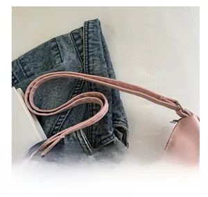 Detailed close-up of the pink plaid bow backpack handle and silver metal zipper closure