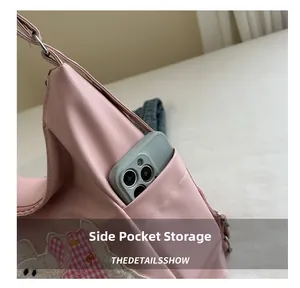 Detail of the side pocket on pink tote bag showing storage for a smartphone