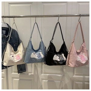 Detail view of large capacity nylon bags in white, blue, black, and pink with puppy embroidery