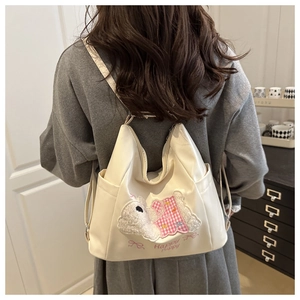 Detail of cute puppy embroidery and Happy Puppy text on white faux leather backpack