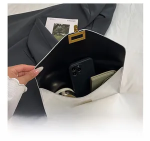 Macro view of silver envelope clutch showing spacious interior with metal lock detail