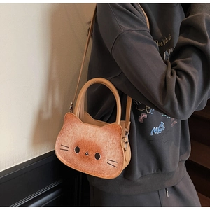 Detail of cute cat shaped crossbody bag with bread texture and shoulder strap shown on model