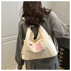 Detail of cute puppy embroidery and Happy Puppy text on white leather tote bag
