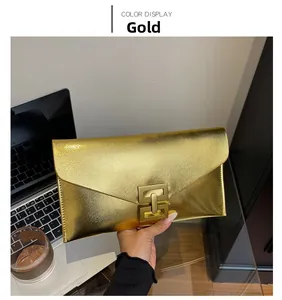 Detail of metallic gold clutch bag featuring a brushed texture and rectangular clasp