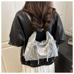 Détail montrant la texture métallique argentée et le nœud du sac à dos tendance pour femme