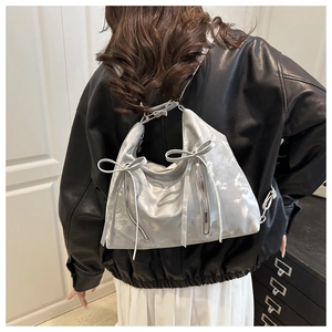 Détails du sac cabas argent métallisé avec des nœuds décoratifs et doubles fermetures
