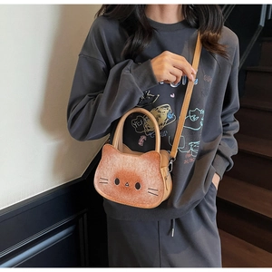 Detail of cat-shaped crossbody bag featuring fine PU leather texture and metal buckles