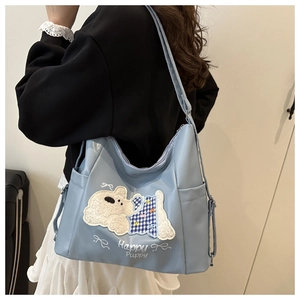 Detail of light blue PU tote bag with cute white puppy patch and side pocket on shoulder