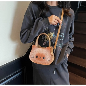 Detail of cute cat shaped crossbody bag in caramel toast brown with detachable strap