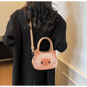 Detailed back view of a cute cat-shaped crossbody bag worn by a model in brown