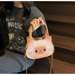 Detail of caramel cat-shaped handbag with toasted bread texture and removable strap
