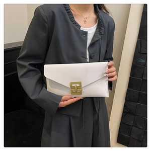Close-up of a white envelope clutch bag featuring a golden geometric clasp and crossgrain leather