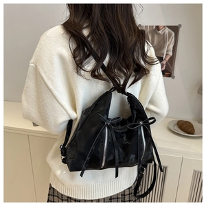 Détail du ruban nœud noir et de la fermeture éclair argentée d'un sac à dos nylon