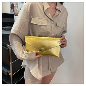 Close-up of golden shimmer envelope clutch featuring a metallic H-shaped buckle lock