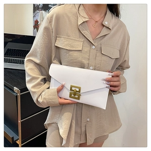 Close-up of a white envelope clutch bag featuring a vintage bronze square metal buckle