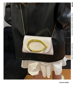 Détail d'un sac bandoulière en similicuir crème avec une grande boucle en métal doré