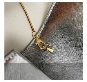 Vue macro détaillée de la chaîne serpent dorée et du fermoir sur le sac boîte chic
