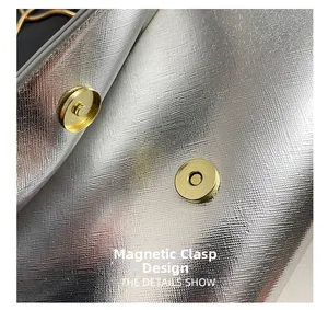 Détail des doubles fermoirs magnétiques dorés sur le sac à main texture Saffiano