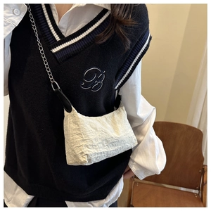 Détail du sac bandoulière blanc cassé avec texture plissée et chaîne en métal argenté
