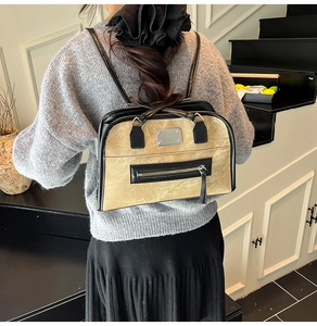 Retro khaki shoulder bag with black trim and silver hardware detail on a model back view