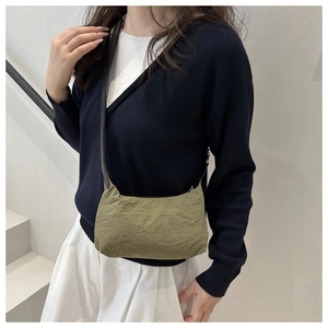 Détail du sac à bandoulière en nylon froissé vert olive porté par un mannequin femme