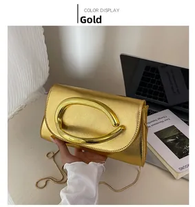Détail de l'élégant sac de soirée doré avec finition métallique et poignée ovale
