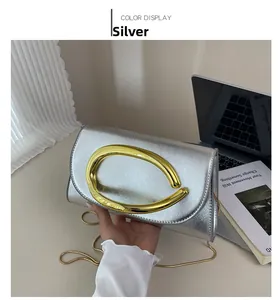 Détail du sac boîte argenté texturé avec boucle dorée et bandoulière chaîne
