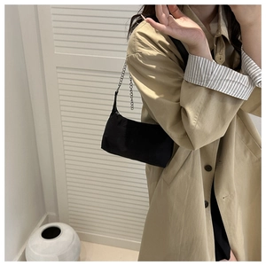 Détail du sac sous l'aisselle noir minimaliste avec bandoulière en chaîne de métal argenté
