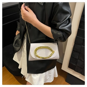 Détail du sac bandoulière en cuir blanc avec boucle C dorée géante et bandoulière chaîne