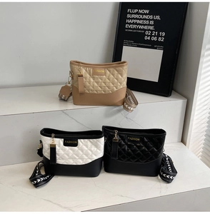 Three quilted rhombus bucket bags in various colors displayed on marble steps